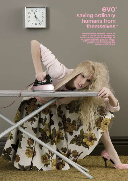 Woman in a floral dress lying on an ironing board with a clock on the wall.